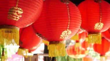 Pejmürde binadaki kağıt fenerler. Doğudaki güneşli bir günde yıpranmış beton tapınak binasının tavanına asılı kırmızı kağıt fenerler. geleneksel dekorasyon