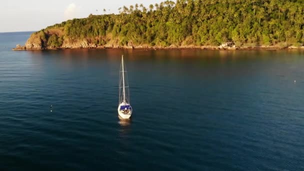 Boat near tropical shore. Amazing drone view of modern white luxury yacht sailing on calm sea water near coast of tropical island. — Stock Video