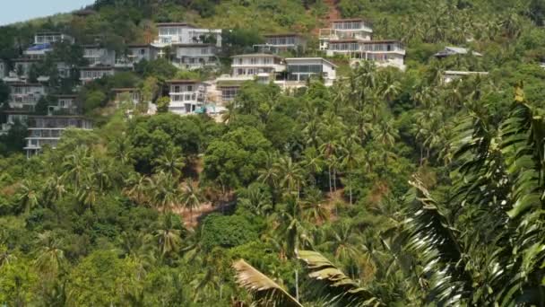 Luxus villák hegyi lejtőn. Drónra néző luxus házak között található egzotikus fák zöld hegyen napsütéses napon a trópusi szigeten. — Stock videók