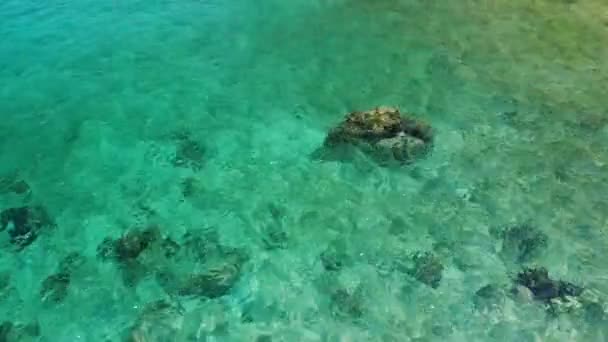 Agua de mar tranquila cerca de las piedras. Agua azul pacífica del mar y rocas grises en el lugar perfecto para bucear en la isla de Koh Tao en el día soleado en Tailandia. Textura de fondo natural. — Vídeo de stock