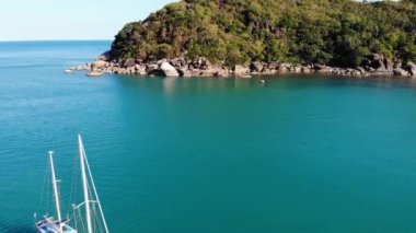Tropikal kıyıya yakın bir tekne. Tropik volkanik adanın kıyıları yakınlarındaki sakin deniz suyunda seyreden modern yatın insansız hava aracı görüntüsü. Egzotik Cennet Koh Samui, Silver Beach.