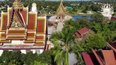 Gölün yakınındaki Budist Tapınağı. Ko Samui güneşli bir gün göl yakınında bulunan muhteşem Budist tapınağın çatılar ve heykellerin drone üst görünümü. Wat Plai Laem ile gülümseyen Buddha ve Guan Yin