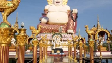 Budist tapınağının dışındaki Hotei heykeli. Asya ülkesinde bulutsuz mavi gökyüzüne karşı Budizm Tapınağın bahçesinde bulunan geleneksel mutlu Hotei heykel. Wat Plai Laem. Koh Samui.