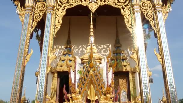 Ornamentales Dach eines orientalischen Tempels. goldenes Zierdach eines traditionellen asiatischen Tempels vor wolkenlosem blauen Himmel an sonnigen Tagen. wat plai laem. koh samui. — Stockvideo