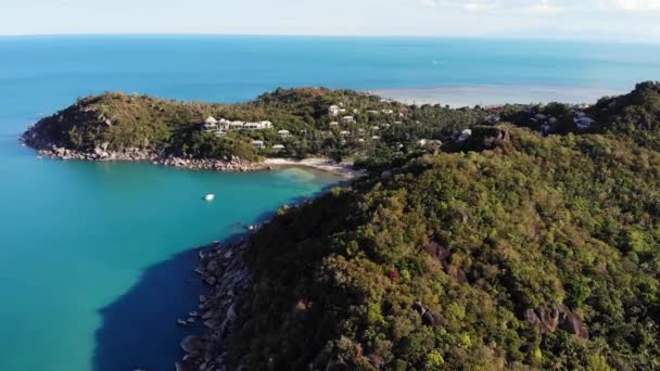 Ruhiges Meer in der Nähe tropischer Vulkaninsel. Drohne Blick auf das ruhige Wasser des blauen Meeres in der Nähe steinigen Ufers und grünen Dschungel der vulkanischen Koh Samui Insel an einem sonnigen Tag in Thailand. Silberstrand. — Stockvideo