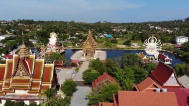 Gölün yakınındaki Budist Tapınağı. Ko Samui güneşli bir gün göl yakınında bulunan muhteşem Budist tapınağın çatılar ve heykellerin drone üst görünümü. Wat Plai Laem ile gülümseyen Buddha ve Guan Yin