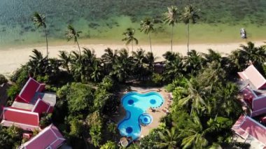 Deniz kıyısındaki oryantal evler. Güzel oryantal evler ve yeşil Hindistan cevizi avuç içinde güneşli bir gün tatil üzerinde sakin deniz kıyısında bulunan drone görünümü