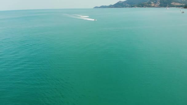 Unbekannter fährt Wasserroller. Ein unkenntlich gemachter Tourist fährt auf einem modernen Wasserroller auf dem blauen Wasser des Meeres am Urlaubsort. koh samui paradise exotic chaweng beach drone view. — Stockvideo