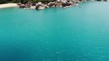 Tropikal adada küçük evler. Güneşli Tayland 'da güneşli bir günde, Koh Samui adasının kıyısındaki küçük, rahat bungalovlar. Volkanik kayalar ve uçurumlar insansız hava aracı görüntüsü.