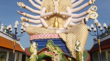 Budizm tapınağının bahçesindeki Guanyin Heykeli. Guan Yin heykeli birçok silah doğu ülkede bulutsuz mavi gökyüzüne karşı geleneksel Budist tapınağının bahçesinde bulunan. Wat Plai Laem. Koh Samui.