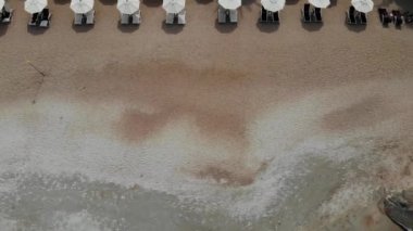 Plajda şezlong. Temiz kum ile ıssız plajda şemsiye ile birçok eşleştirilmiş şezlong havadan görünümü.