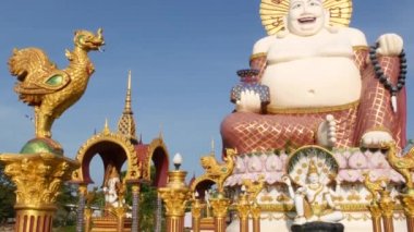 Budist tapınağının dışındaki Hotei heykeli. Asya ülkesinde bulutsuz mavi gökyüzüne karşı Budizm Tapınağın bahçesinde bulunan geleneksel mutlu Hotei heykel. Wat Plai Laem. Koh Samui.