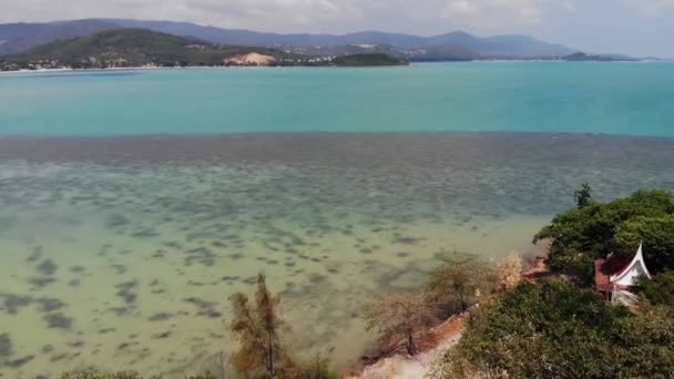 Ilha com templo budista e muitas casas. Vista aérea da ilha com templo budista com estátua Grande Buda cercado por casas tradicionais em palafitas na baía do oceano Pacífico em Samui, Tailândia. — Vídeo de Stock