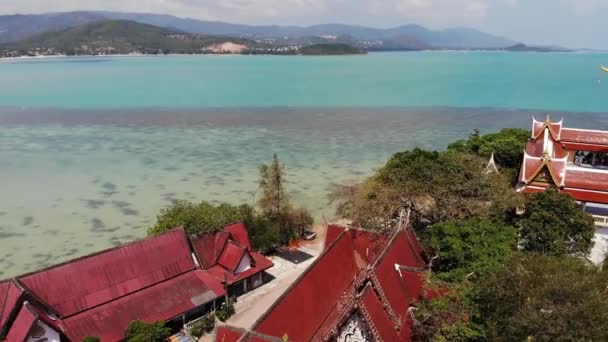 Νησί με βουδιστικό ναό και πολλά σπίτια. Αεροφωτογραφία του νησιού με βουδιστικό ναό με άγαλμα Big Buddha περιβάλλεται από παραδοσιακά σπίτια σε ξυλοπόδαρα στον κόλπο του Ειρηνικού Ωκεανού για Samui, Ταϊλάνδη. — Αρχείο Βίντεο