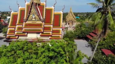 Gölün yakınındaki Budist Tapınağı. Ko Samui güneşli bir gün göl yakınında bulunan muhteşem Budist tapınağın çatılar ve heykellerin drone üst görünümü. Wat Plai Laem ile gülümseyen Buddha ve Guan Yin
