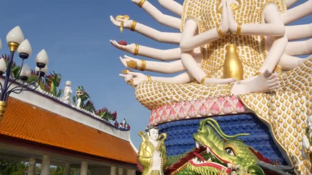 Estatua de Guanyin en el patio del templo Buddhism. Estatua de Guan Yin con muchos brazos ubicados en el patio del templo budista tradicional contra el cielo azul sin nubes en el país oriental. Wat Plai Laem. Koh Samui. . — Vídeos de Stock