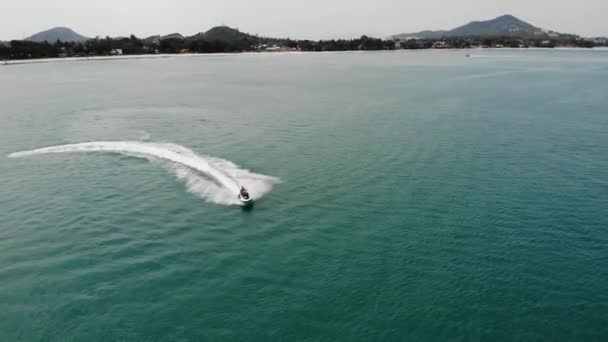 Anonymní osoba jezdila na skútru. Nerozpoznatelný turista moderního vodního skútru na modré mořské vodě na letovisku. Koh Samui, exotický pohled na pláž Chaweng. — Stock video