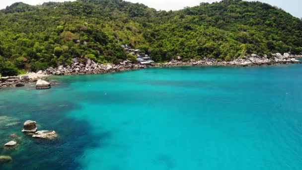 Mar calmo perto da ilha vulcânica tropical. Vista drone da água pacífica do mar azul perto da costa pedregosa e selva verde da ilha vulcânica de Koh Tao no dia ensolarado na Tailândia. — Vídeo de Stock