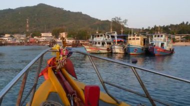 Tayland Ko Tao Adası'nda dalış tesisi limanına doğru yüzen dini tılsımlar ile parlak tekne