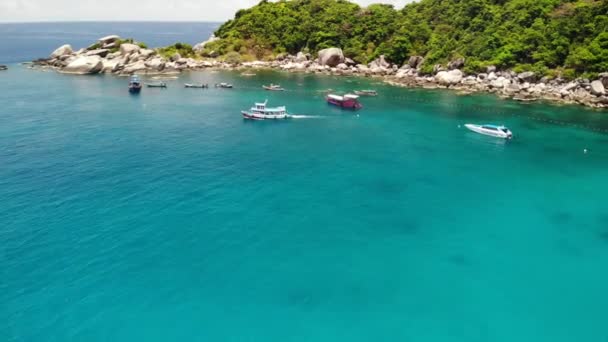 Barcos turísticos na baía tropical. Vista drone de barcos turísticos com mergulhadores e snorkelers flutuando na água do mar calma em Hin Wong Bay da ilha vulcânica tropical Koh Tao na Tailândia. — Vídeo de Stock