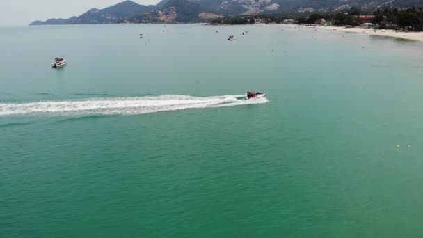 Unbekannter fährt Wasserroller. Ein unkenntlich gemachter Tourist fährt auf einem modernen Wasserroller auf dem blauen Wasser des Meeres am Urlaubsort. koh samui paradise exotic chaweng beach drone view. — Stockvideo