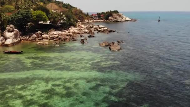 Pequeñas casas en la isla tropical. Pequeños y acogedores bungalows situados en la orilla de la isla de Koh Tao cerca del mar tranquilo en un día soleado en Tailandia. — Vídeo de stock