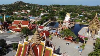 Gölün yakınındaki Budist Tapınağı. Ko Samui güneşli bir gün göl yakınında bulunan muhteşem Budist tapınağın çatılar ve heykellerin drone üst görünümü. Wat Plai Laem ile gülümseyen Buddha ve Guan Yin