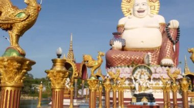 Budist tapınağının dışındaki Hotei heykeli. Asya ülkesinde bulutsuz mavi gökyüzüne karşı Budizm Tapınağın bahçesinde bulunan geleneksel mutlu Hotei heykel. Wat Plai Laem. Koh Samui.