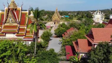 Gölün yakınındaki Budist Tapınağı. Ko Samui güneşli bir gün göl yakınında bulunan muhteşem Budist tapınağın çatılar ve heykellerin drone üst görünümü. Wat Plai Laem ile gülümseyen Buddha ve Guan Yin