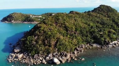 Tropikal volkanik ada yakınında sakin deniz. Tayland güneşli bir günde taşlı kıyı ve volkanik Koh Samui Adası yeşil orman yakınında mavi deniz huzurlu su Drone görünümü. Gümüş Plaj.