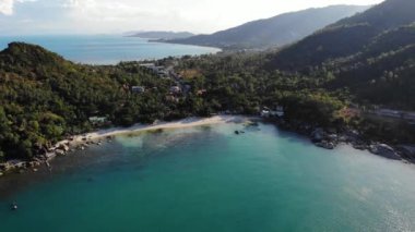 Tropikal kıyıya yakın bir tekne. Tropik volkanik adanın kıyıları yakınlarındaki sakin deniz suyunda seyreden modern yatın insansız hava aracı görüntüsü. Egzotik Cennet Koh Samui, Silver Beach.