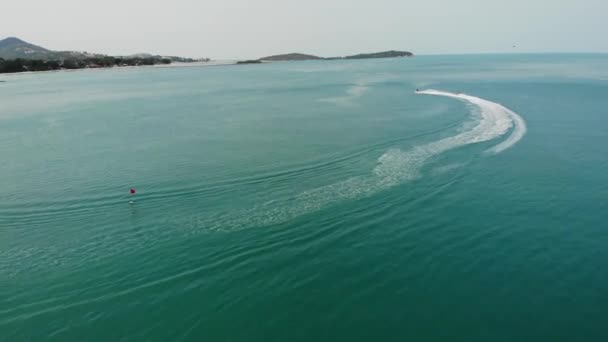 Pessoa anônima montando scooter de água. Turista irreconhecível montando scooter de água moderna na água azul do mar no resort. Koh Samui paraíso exótico Chaweng praia drone vista . — Vídeo de Stock