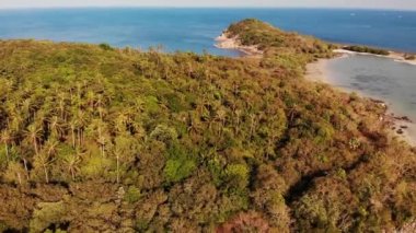 Okyanustaki küçük ada ve mercan resifi. Tropikal doğada güneşli bir günde sakin denizde yeşil ıssız bir ada ve inanılmaz mercan resifinin insansız hava aracı görüntüsü. Koh Samui, Tayland.