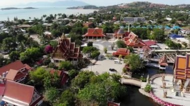 Gölün yakınındaki Budist Tapınağı. Ko Samui güneşli bir gün göl yakınında bulunan muhteşem Budist tapınağın çatılar ve heykellerin drone üst görünümü. Wat Plai Laem ile gülümseyen Buddha ve Guan Yin