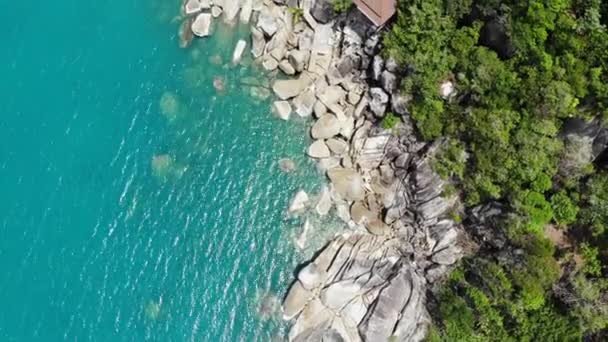 Kleine huizen op tropisch eiland. Kleine gezellige bungalows gelegen aan de kust van Koh Samui Island in de buurt van rustige zee op zonnige dag in Thailand. Vulkanische rotsen en kliffen drone bovenaanzicht. — Stockvideo