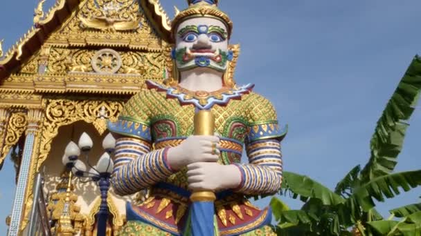 アジアの寺院の近くにカラフルな彫像。東洋の国の晴れた日に観賞用の仏教寺院の近くに位置する2つの明るい多色の彫像。ワット・プレイ・レムの神話の巨大な守護者ヤク。サムイ. — ストック動画