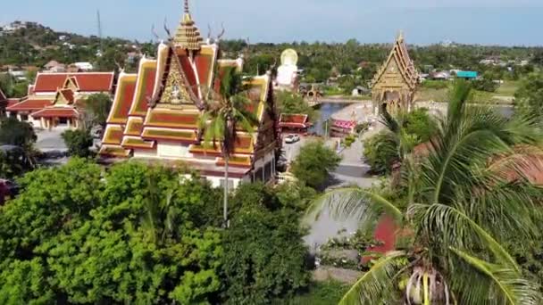 Buddhist temple near lake. Drone top view of roofs and statues of wonderful Buddhist temple located near lake on sunny day on Ko Samui. Wat Plai Laem with Smiling Buddha and Guan Yin — Stock Video