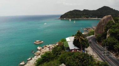 İHA üst görünümü. Deniz kıyısında büyük bir taş. Ana asfalt yolu Tayland 'daki Ko Samui cennet adasındaki turkuaz deniz kıyısında büyük Fil Kayası' nın yakınına gidiyor..