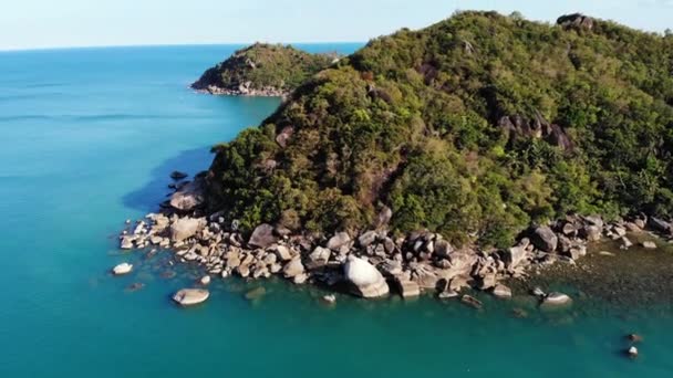 Tropikal volkanik ada yakınında sakin deniz. Tayland güneşli bir günde taşlı kıyı ve volkanik Koh Samui Adası yeşil orman yakınında mavi deniz huzurlu su Drone görünümü. Gümüş Plaj. — Stok video