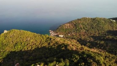 Tropik adanın ormanları ve dağları. Tayland 'ın güneşli bir gününde Koh Tao Adası' nın volkanik kayalık arazisindeki yeşil ormanların ve dev kayaların insansız hava aracı görüntüsü.