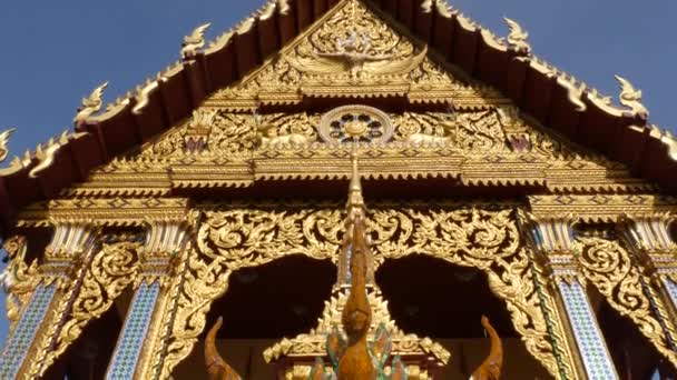 Ornamental roof of oriental temple. Golden ornamental roof of traditional Asian temple against cloudless blue sky on sunny day. Wat Plai Laem. Koh Samui. — Stock Video