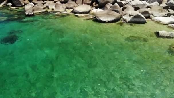 Agua de mar tranquila cerca de las piedras. Agua azul pacífica del mar y rocas grises en el lugar perfecto para bucear en la isla de Koh Tao en el día soleado en Tailandia. Textura de fondo natural. — Vídeo de stock