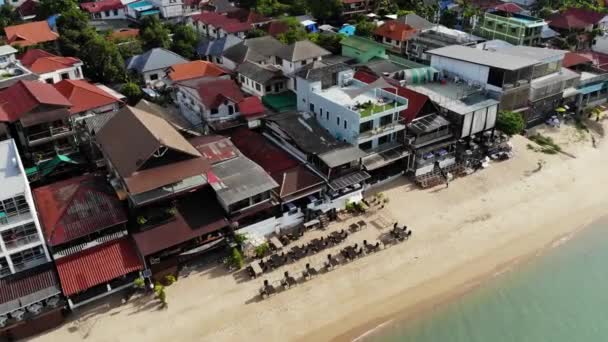Kalastajien kylä meren rannalla. Ilmakuva tyypillinen matkailukohde Ko Samui saarella matkamuistomyymälöitä ja kävely kadulla aurinkoisena päivänä. Arkkitehtuuri Aasiassa, paikallinen ratkaisu drone näkymä — kuvapankkivideo