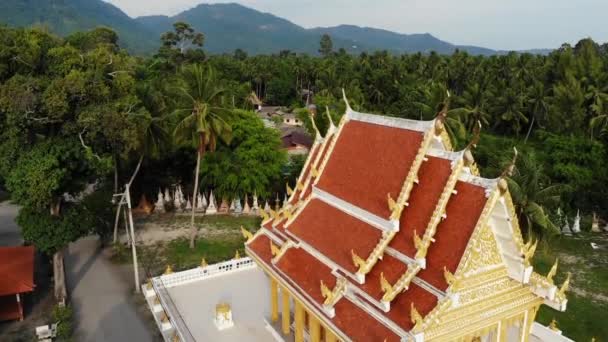 Klassieke boeddhistische tempel tussen bos. Van boven drone uitzicht Boeddhistisch klooster tussen groene bomen in de buurt van heuvel in Thailand. Koh Samui. concept van toerisme, meditatie en oriëntaals leven. Aziatisch dorp — Stockvideo