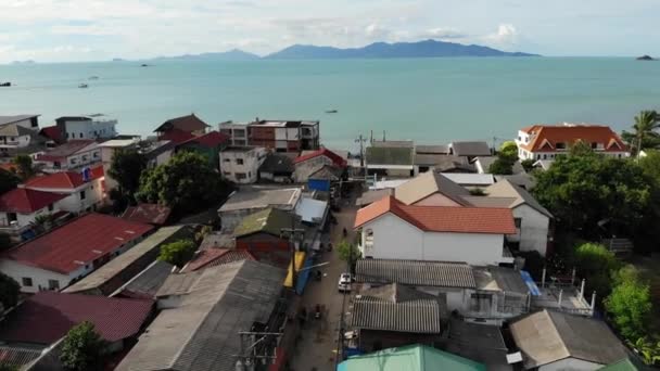 Pueblo de pescadores a orillas del mar. Vista aérea del típico lugar turístico en la isla de Ko Samui con tiendas de recuerdos y calle peatonal en un día soleado. Arquitectura en Asia, vista del dron de asentamiento local — Vídeos de Stock