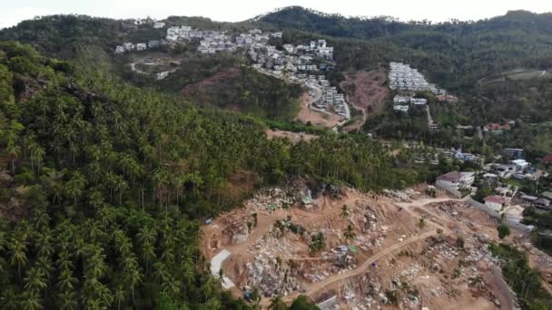 Tropisk terräng täckt med hotade skogar och lyxvillor. Drönare syn på stora tropikerna med ekosystemstörningar på grund av byggnader och avskogning. Det är Koh Samui. Kokospalmplantager. — Stockvideo