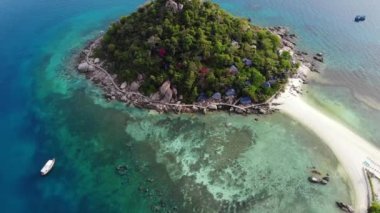 Küçük tropikal volkanik ada Koh Tao yakınlarındaki sakin, masmavi turkuaz deniz, eşsiz küçük cennet Nang Yuan. Güneşli Tayland 'da güneşli bir günde taşlık sahil ve yeşil ormanın yakınındaki huzurlu suyun insansız hava aracı görüntüsü.