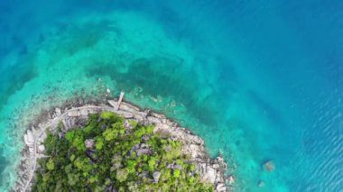 Küçük tropikal volkanik ada Koh Tao yakınlarındaki sakin, masmavi turkuaz deniz, eşsiz küçük cennet Nang Yuan. Güneşli Tayland 'da güneşli bir günde taşlık sahil ve yeşil ormanın yakınındaki huzurlu suyun insansız hava aracı görüntüsü.