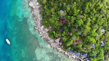 Küçük tropikal volkanik ada Koh Tao yakınlarındaki sakin, masmavi turkuaz deniz, eşsiz küçük cennet Nang Yuan. Güneşli Tayland 'da güneşli bir günde taşlık sahil ve yeşil ormanın yakınındaki huzurlu suyun insansız hava aracı görüntüsü.