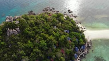 Küçük tropikal volkanik ada Koh Tao yakınlarındaki sakin, masmavi turkuaz deniz, eşsiz küçük cennet Nang Yuan. Güneşli Tayland 'da güneşli bir günde taşlık sahil ve yeşil ormanın yakınındaki huzurlu suyun insansız hava aracı görüntüsü.